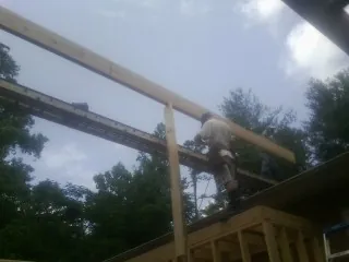 Carpenter setting a ridge beam over a new addition frame — Ice Dam Removal by Roofing Brothers in King Ferry