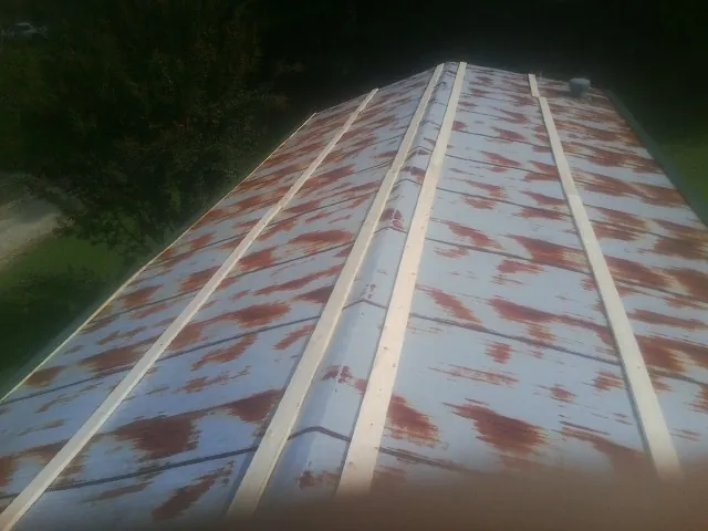 Rusted metal roof panels with new wood purlins before replacement — Storm Damage Roof Repair in King Ferry by Roofing Brothers