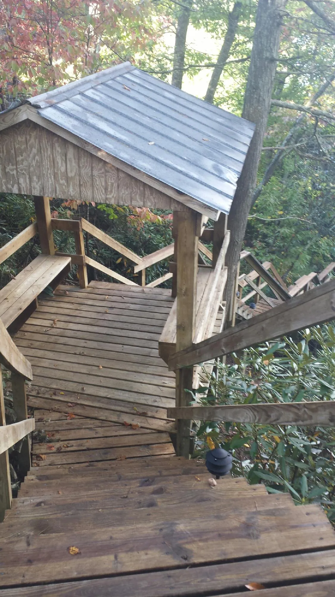 Metal roofed shelter over wooden steps on a wooded walkway — Skylight Repair & Installation work by our crew in King Ferry