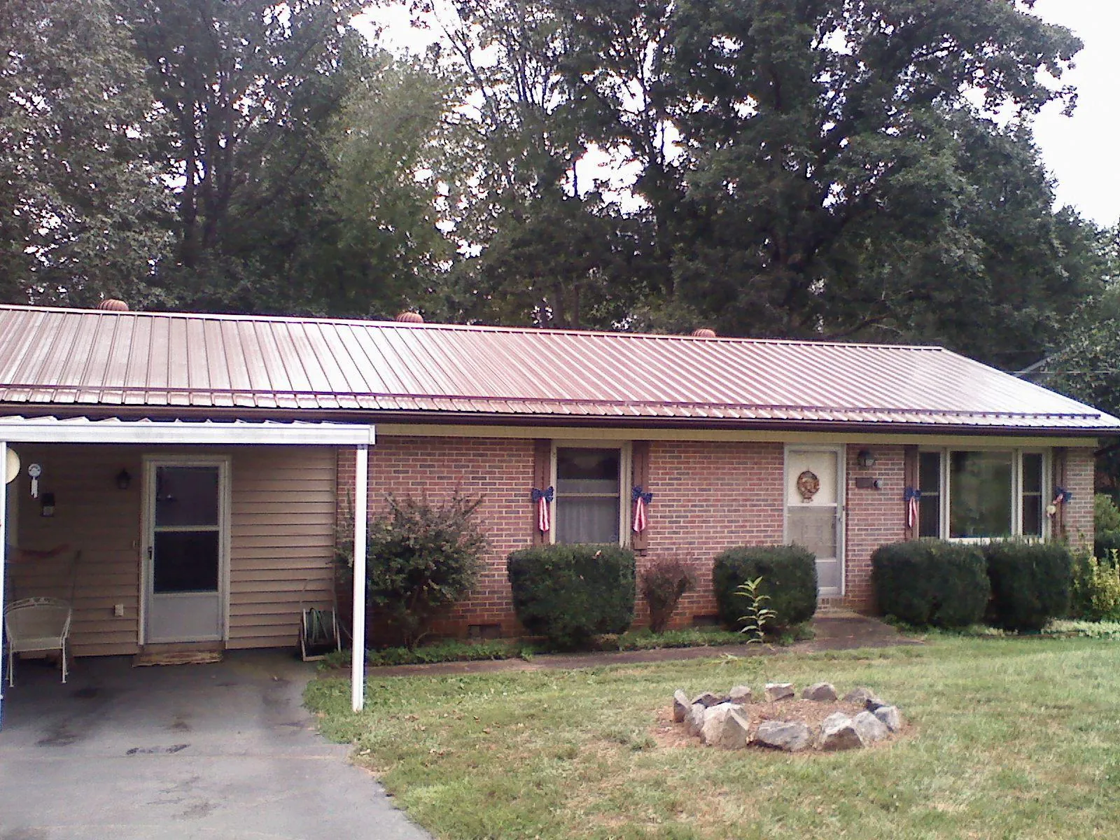 Bronze metal roof and carport on a brick ranch home — Roof Repair work by our crew in King Ferry